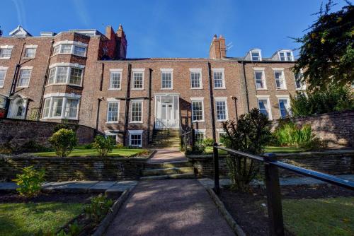 a large brick building with a staircase in front of it at White Linen Whitby, Room Only in Whitby