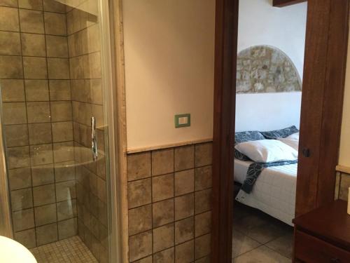 a bathroom with a shower and a bedroom with a bed at La Taverna @ Casale Corneto in Bomba
