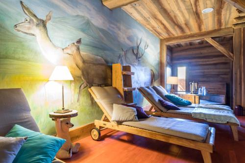 a room with three beds and a mural of deer at Résidence Pierre & Vacances Premium Les Alpages de Chantel in Arc 1800