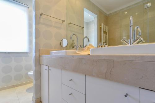 baño con lavabo y espejo grande en Estoril Garden Villa - 4Bedroom private pool - CheckinHome en Alcabideche