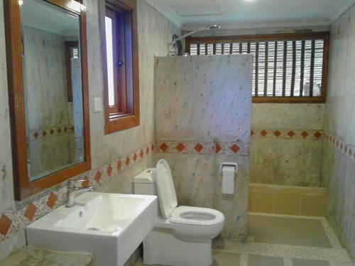 a bathroom with a sink and a toilet and a mirror at Tanjung Inn in Kuantan