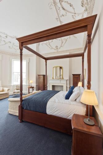 a bedroom with a wooden canopy bed with a lamp at Henrietta Suites City Centre in Dublin