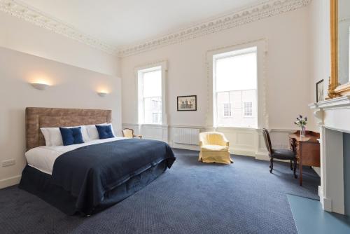 a bedroom with a bed and a desk and windows at Henrietta Suites City Centre in Dublin