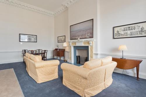 a living room with two chairs and a fireplace at Henrietta Suites City Centre in Dublin