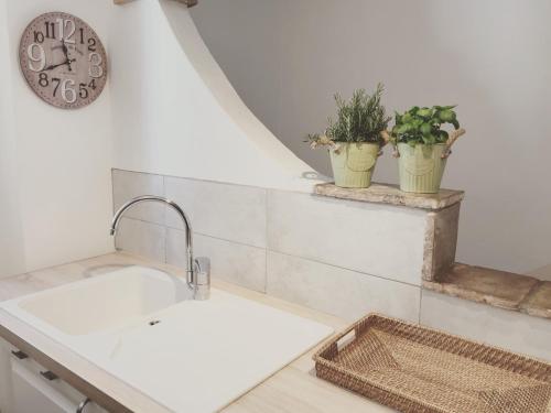 a kitchen with a sink and two potted plants at Maison coeur de village Ramatuelle in Ramatuelle