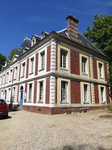 a large red and white brick building with a chimney at Manoir de Bolbec in Bolbec
