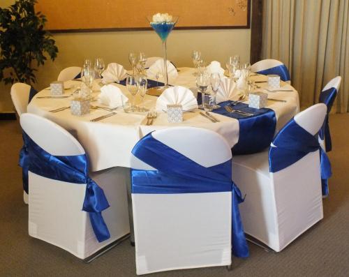 a table with blue and white chairs around it at Dunedin Leisure Lodge - Distinction in Dunedin