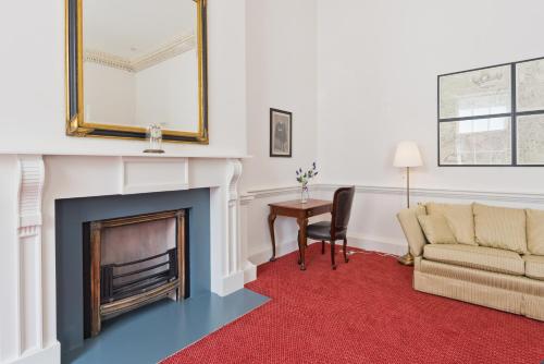 a living room with a fireplace and a couch and a table at Henrietta Suites City Centre in Dublin