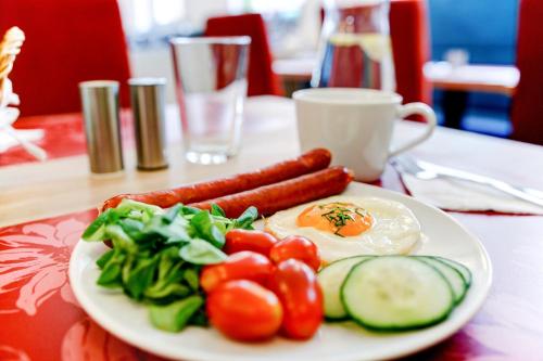 a plate of food with eggs and vegetables on a table at Hotel Koflík in Strakonice