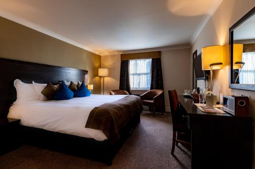 a hotel room with a bed and a desk at Rose And Crown Hotel in London