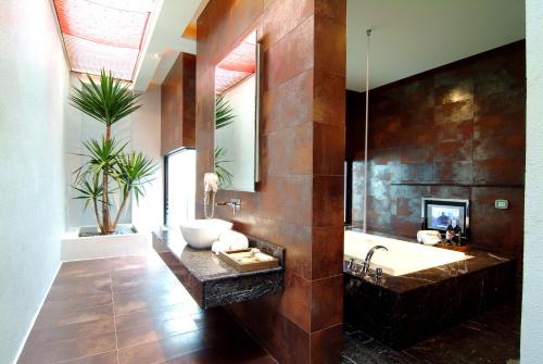 a bathroom with a tub and a sink and a mirror at Takao Love Motel in Kaohsiung