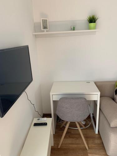 escritorio blanco con silla y TV en Maša Studio Apartman en Brčko