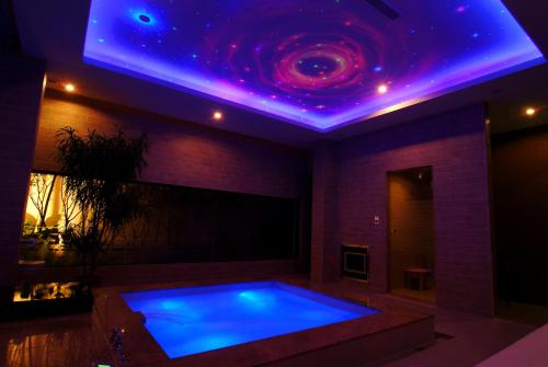 a swimming pool with a purple lighting in a room at Takao Love Motel in Kaohsiung