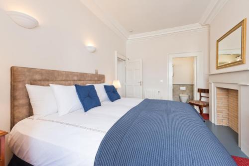 a bedroom with a blue and white bed with a fireplace at Henrietta Suites City Centre in Dublin