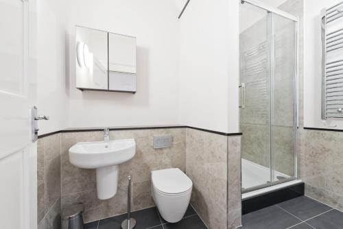 a bathroom with a toilet and a sink and a shower at Henrietta Suites City Centre in Dublin