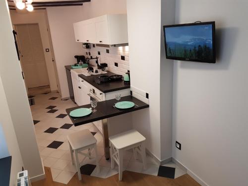 a kitchen with a table and a tv on a wall at La Bonbonnière de Salomé Hyper centre parking possible in Rouen