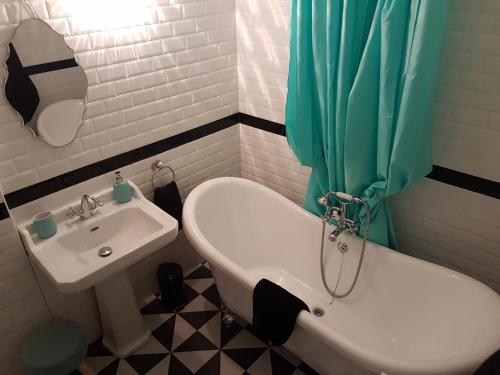 a bathroom with a sink and a toilet and a shower curtain at La Bonbonnière de Salomé Hyper centre parking possible in Rouen