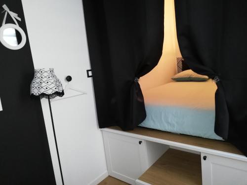 um quarto com uma cama com cortinas pretas em La Bonbonnière de Salomé Hyper centre parking possible em Rouen