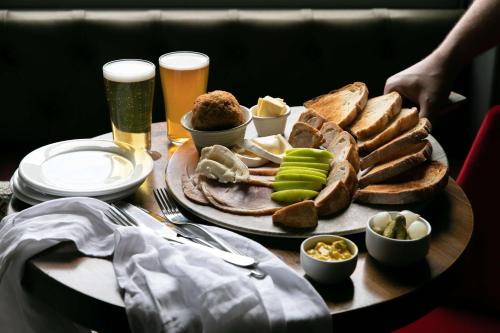 a table topped with a plate of food and drinks at Rose And Crown Hotel in London
