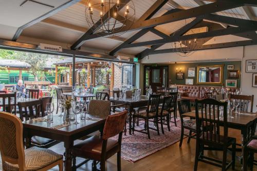 a restaurant with tables and chairs in a room at Rose And Crown Hotel in London