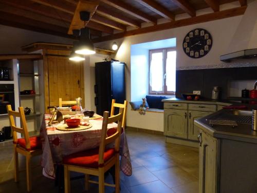 cocina con mesa, sillas y nevera en Gite de l'Amistat, en Vicdessos