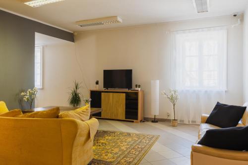 a living room with a couch and a tv at Kuressaare Central Hostel in Kuressaare