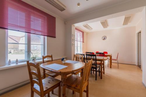 a dining room with tables and chairs and windows at Kuressaare Central Hostel in Kuressaare