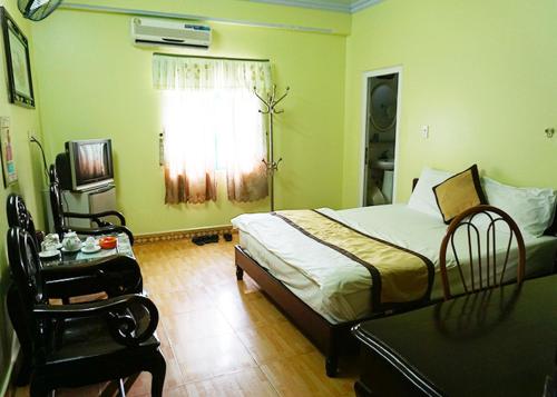 a bedroom with a bed and a table and a window at KHÁCH SẠN NGỌC LY 2 in Thanh Hóa