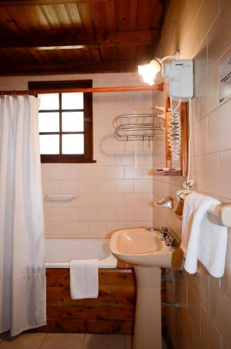a bathroom with a sink and a bath tub at Cabañas El Chalten in Esquel