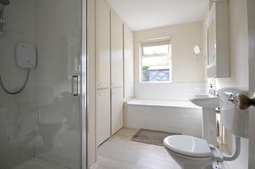 y baño con ducha, aseo y lavamanos. en Cottage 170 - Roundstone, en Roundstone