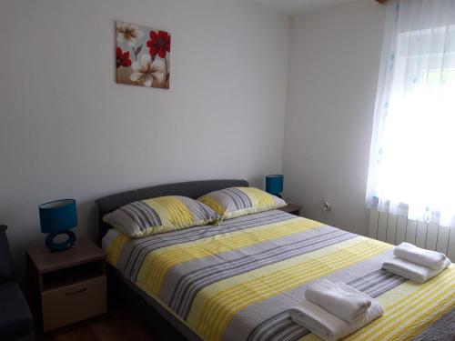a bedroom with a bed with towels on it at Apartment Sanja in Smoljanac