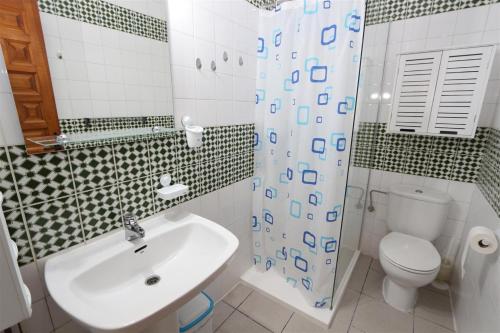 y baño con lavabo, aseo y ducha. en Apartment overlooking to the pool 2450, en La Mata