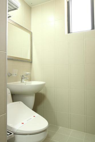 a white bathroom with a toilet and a sink at Residence Hotel Lamia in Daejeon