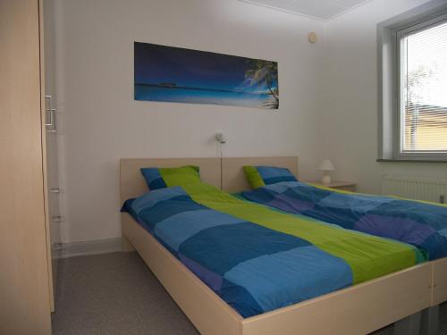 ein Schlafzimmer mit einem Bett mit einer blauen und gelben Decke in der Unterkunft Vestergade 7 Holiday Apartments in Frederikshavn