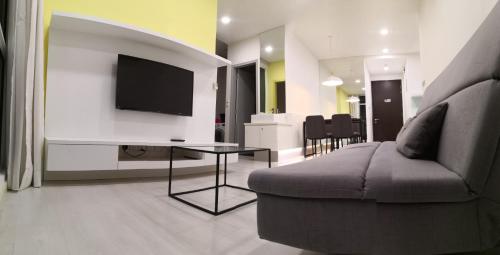 a living room with a couch and a flat screen tv at Strait Garden Suites X Ace Pro @ George Town in Jelutong