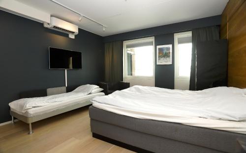 um quarto com 2 camas e uma televisão de ecrã plano em City center Oslo, Luxury Sørenga with sea view, 2 toilet, 2bedrooms em Oslo