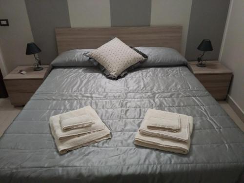 - un lit avec 2 serviettes et 2 tables de nuit dans l'établissement Roma 12, à Messina