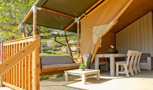 a gazebo with a bench and a table on a deck at Veragua. Glamping y Apartamentos turísticos in Villanueva de la Vera