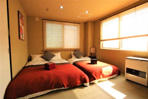 a bedroom with a large bed with a red blanket at Wayado Sapporo Ciao in Sapporo