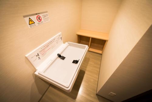 a white sink in a room with a sign on the wall at Super Hotel Premier Tokyo Station Yaesu-Chuoguchi in Tokyo