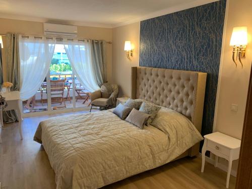 a bedroom with a large bed and a balcony at Laukamao Praia Da Rocha in Portimão
