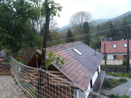 a house with a red roof and a fence at Zempléni Pitvaros Pihenő in Telkibánya
