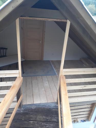 an attic room with a ladder and a closet at Zempléni Pitvaros Pihenő in Telkibánya