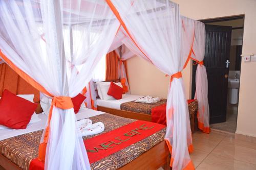 a bedroom with two beds with orange and white curtains at Ocean View Nyali Boutique Hotel in Nyali