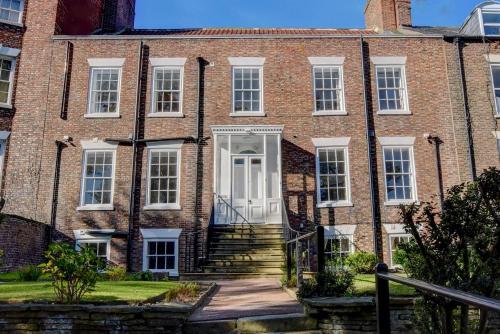 an old brick building with a white door at White Linen Whitby, Room Only in Whitby