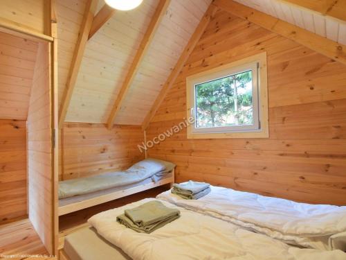 um quarto com duas camas num chalé de madeira em Ustronne Domki em Ustronie Morskie