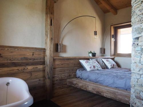 ein Schlafzimmer mit Bett, Fenster und Badewanne in der Unterkunft Virasol in Dronero