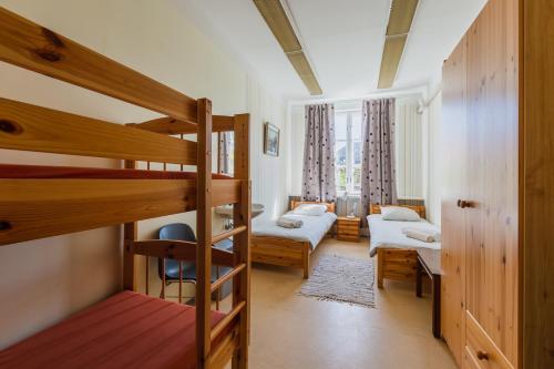 a room with two bunk beds and a living room at Kuressaare Central Hostel in Kuressaare