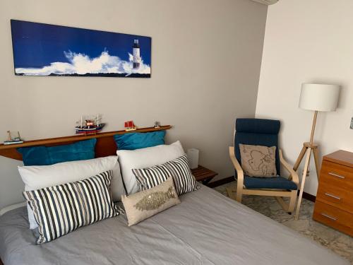 a bedroom with a bed with pillows and a chair at Ocean in Bordighera