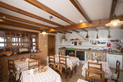 een keuken met tafels en stoelen in een kamer bij Hotel Rural As Laguas in Tapia de Casariego